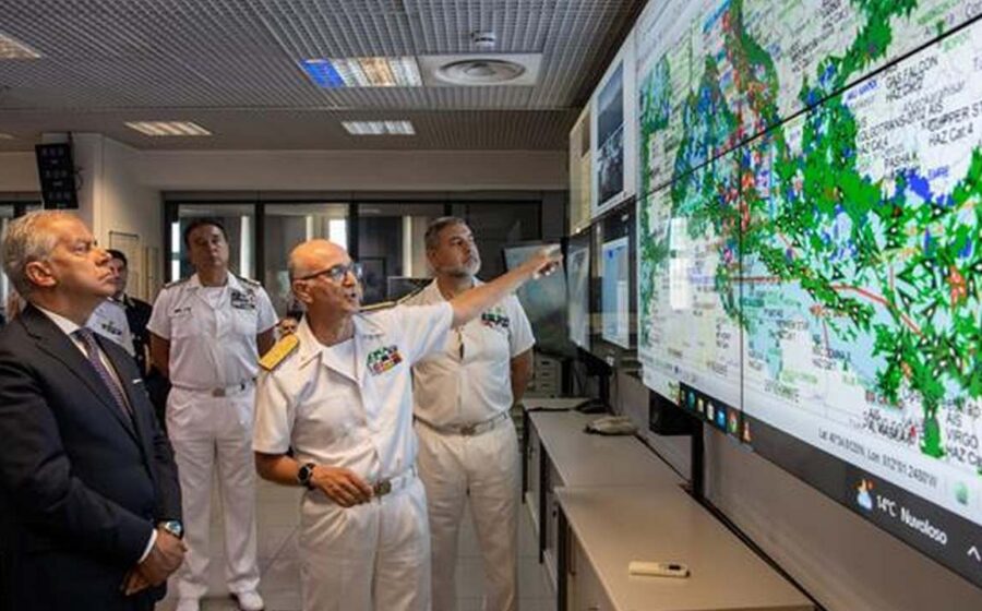 Tecnici davanti alla parete cartografica della centrale della Guardia Costiera