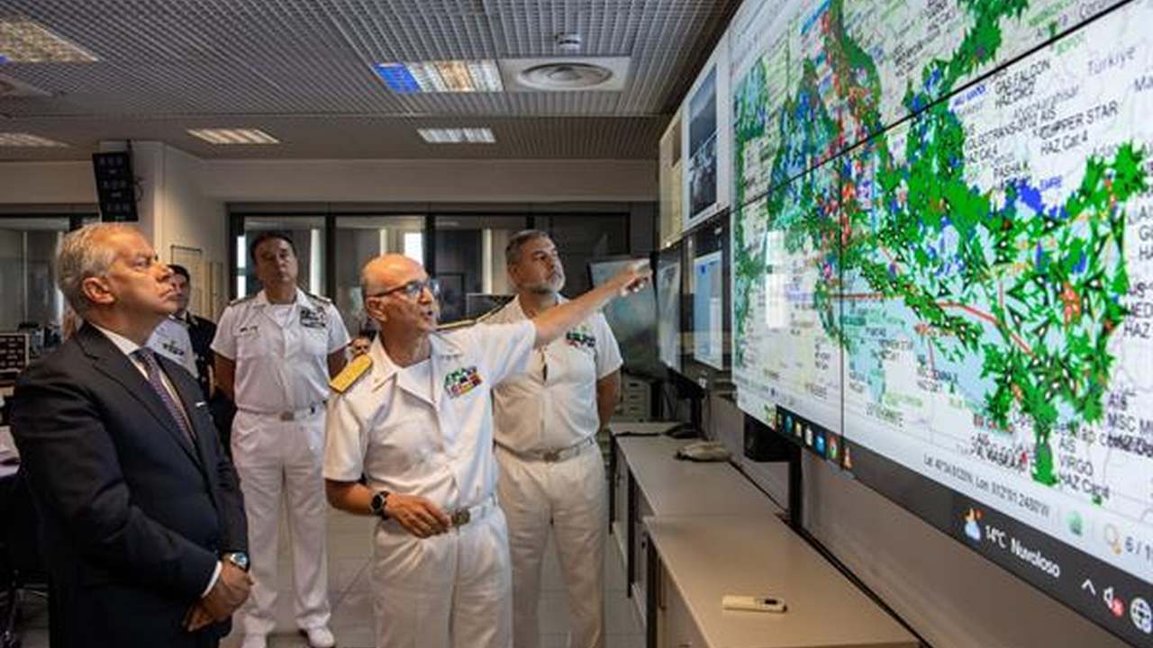 Tecnici davanti alla parete cartografica della centrale della Guardia Costiera