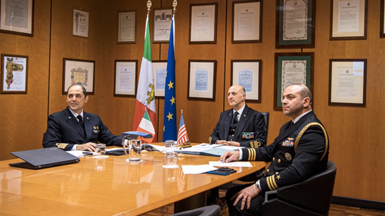 Riunione operativa con carte nautiche e documenti sul tavolo