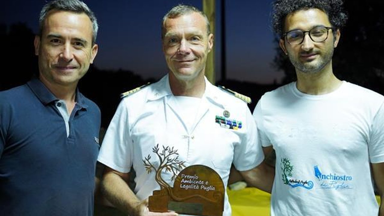 Ufficiale della Guardia Costiera con rappresentanti di un progetto sociale